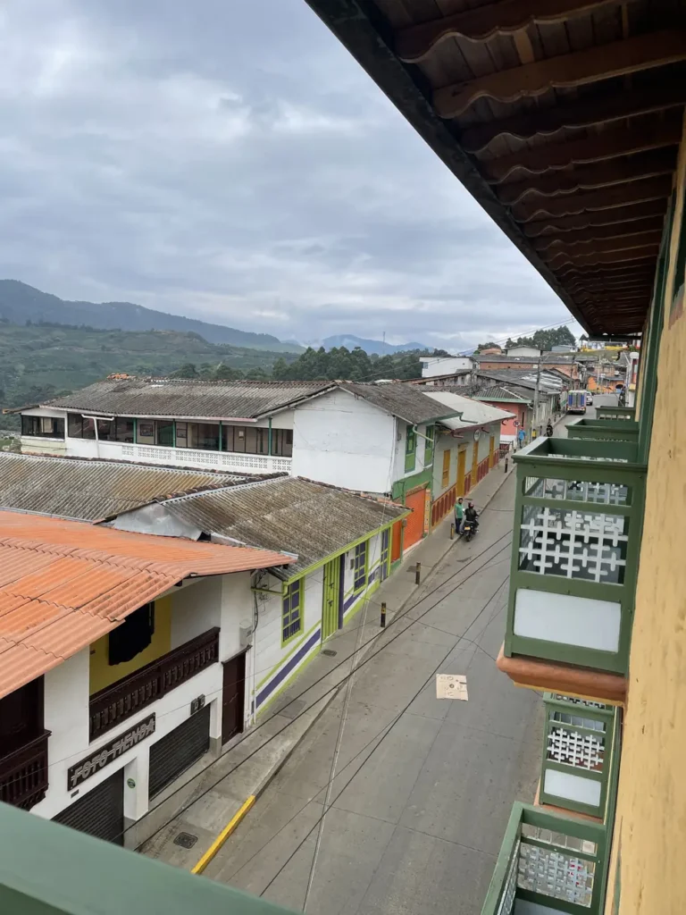 A view down a Concordia street from an upper balcony, over terracotta roofs and painted facades