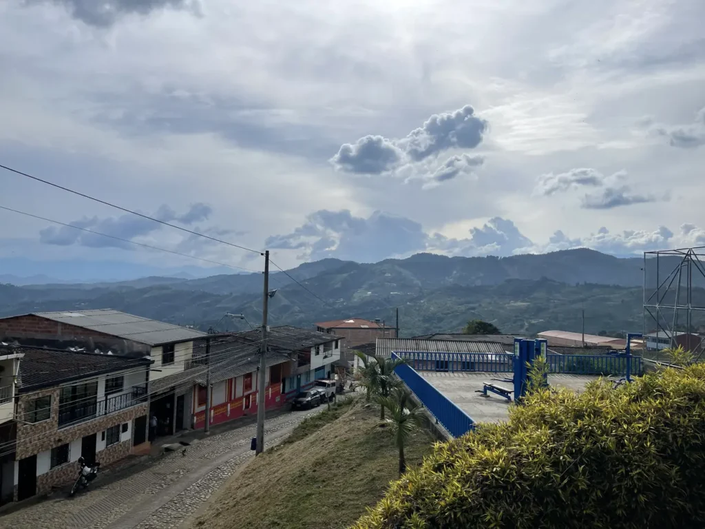 Concordia seen from the road above the town, low houses against a wall of green hills